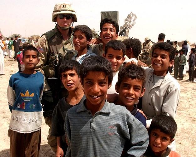 Capt. Jimmie Cummings, commander, 49th Public Affairs Detachment, 82nd Airborne Division is surrounded by children during a humanitarian assistance mission outside As Samawan in central Iraq. (U.S. Army photo by Staff Sgt. Eric Foltz, 49th PAD)