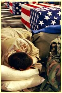 Title..'The Air Force remembers'Army Sgt. Osvaldo Ortiz sleeps next to the transfer case and gear of his fallen friend aboard a C-17 Globemaster III bound for Dover Air Force Base, Del. Ortiz is accompanying the remains to the base and eventually back to the fallen soldier's home in Puerto Rico. (U.S. Army photo by Staff Sgt. Peter Rimar)