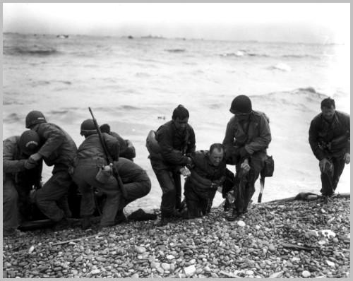 Members of an American landing party lend helping hands to other members of their organization whose landing craft was sunk by enemy action off the coast of France. These survivors reached Omaha Beach, near Cherbourg, by using a life raft. Photographer: Weintraub, 6 June 1944 Photo Source: http://www.army.mil/